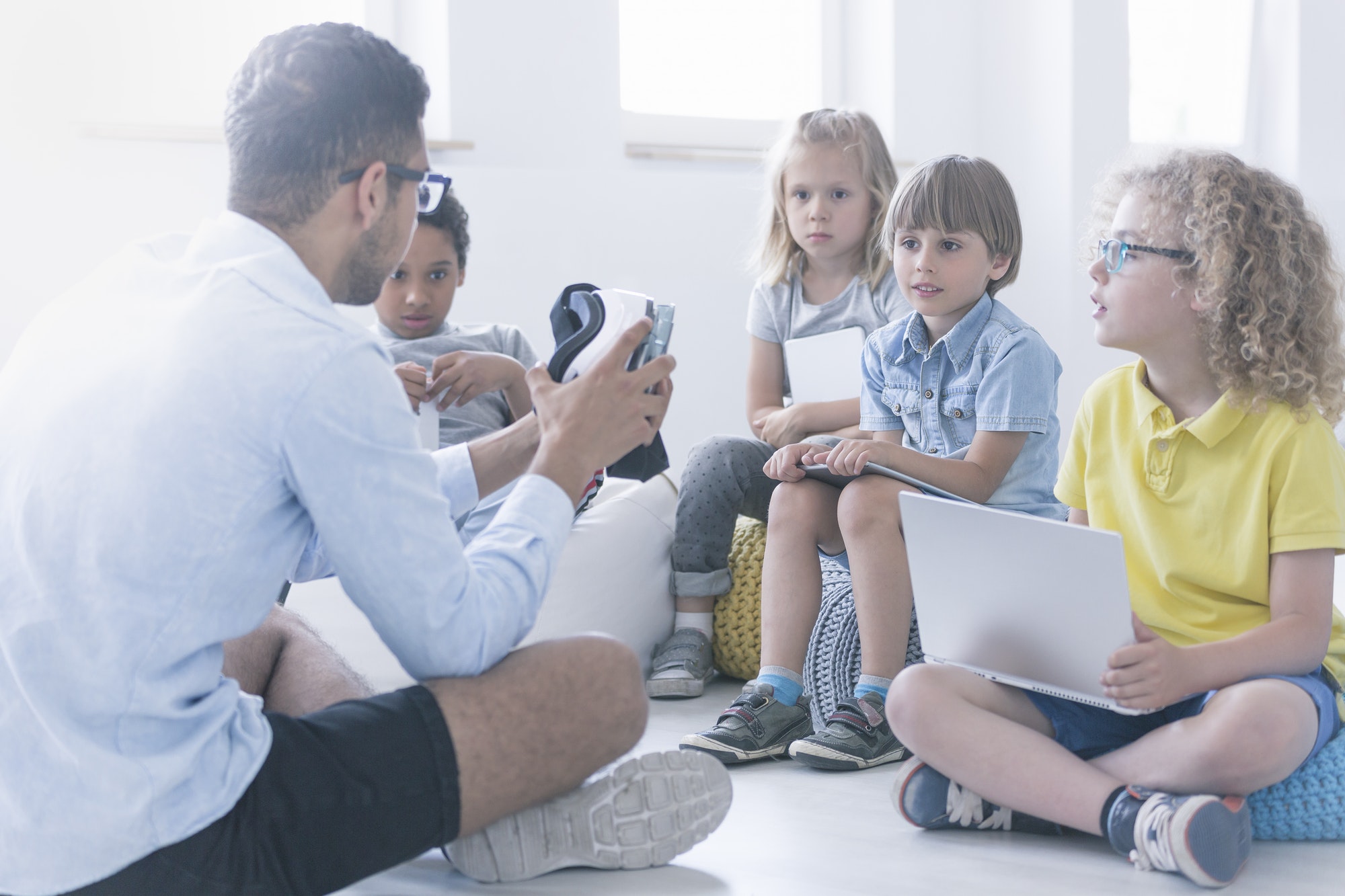 Happy teacher shows children the robot